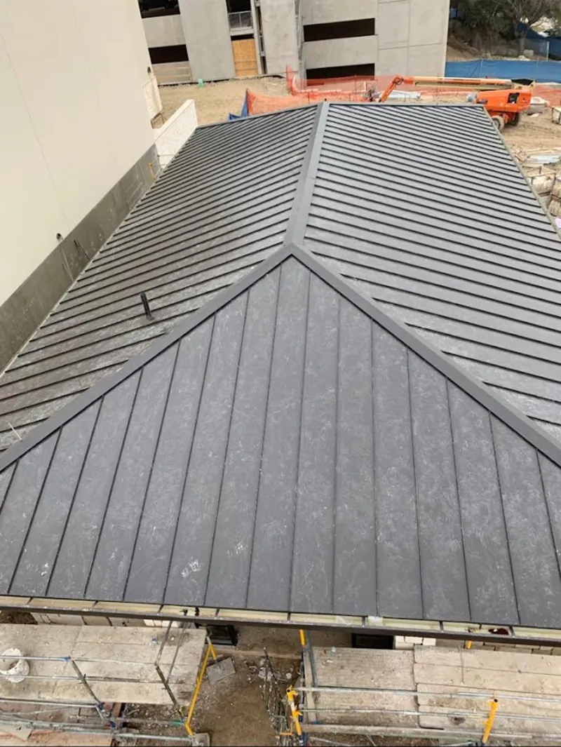 Commercial metal roof construction with crane equipment in Wolfforth